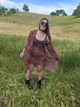 girl in field with mesh dress and kimono for music festival vintage 70s style